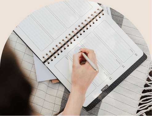 mano de una chica apuntando cosas en una agenda